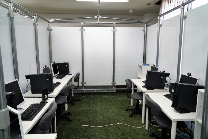 白い壁に囲まれ、パソコンデスクが配置された5人収容のスペース