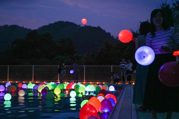 プールに浮かぶ色とりどりの風船がライトで明るくなっており、幻想的な雰囲気を醸し出す