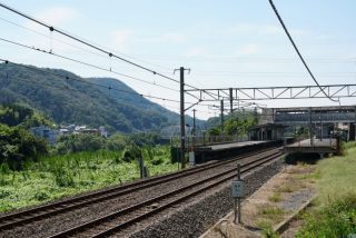 山間にあるJR大和路線の三郷駅。奥には大和川を渡る橋梁。